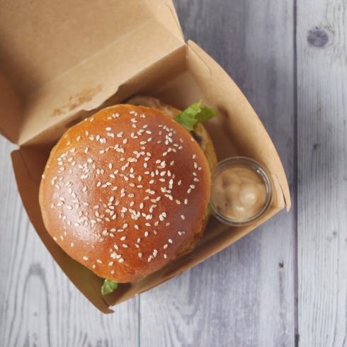 beef burger and french fries in a takeaway paper box on table